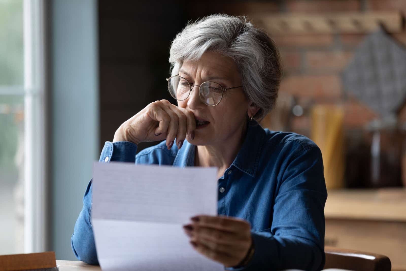 Business woman frowning as she reviews paperwork.