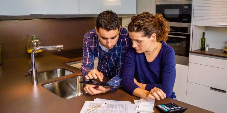 couple-working-out-bills-in-kitchen.CDN5e66117f