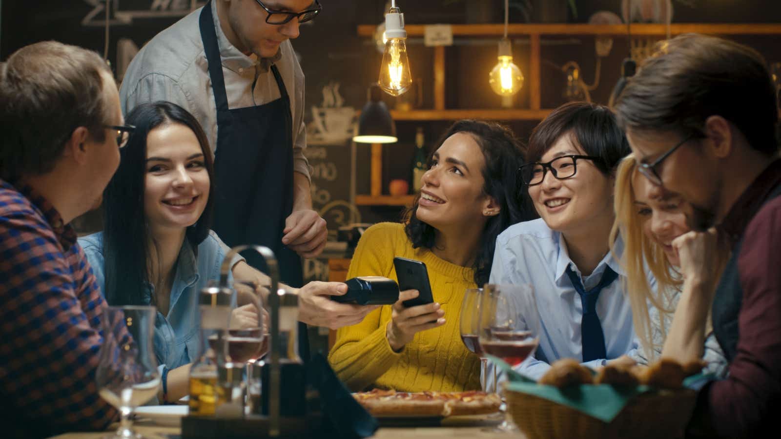 Group at restaurant paying by card.